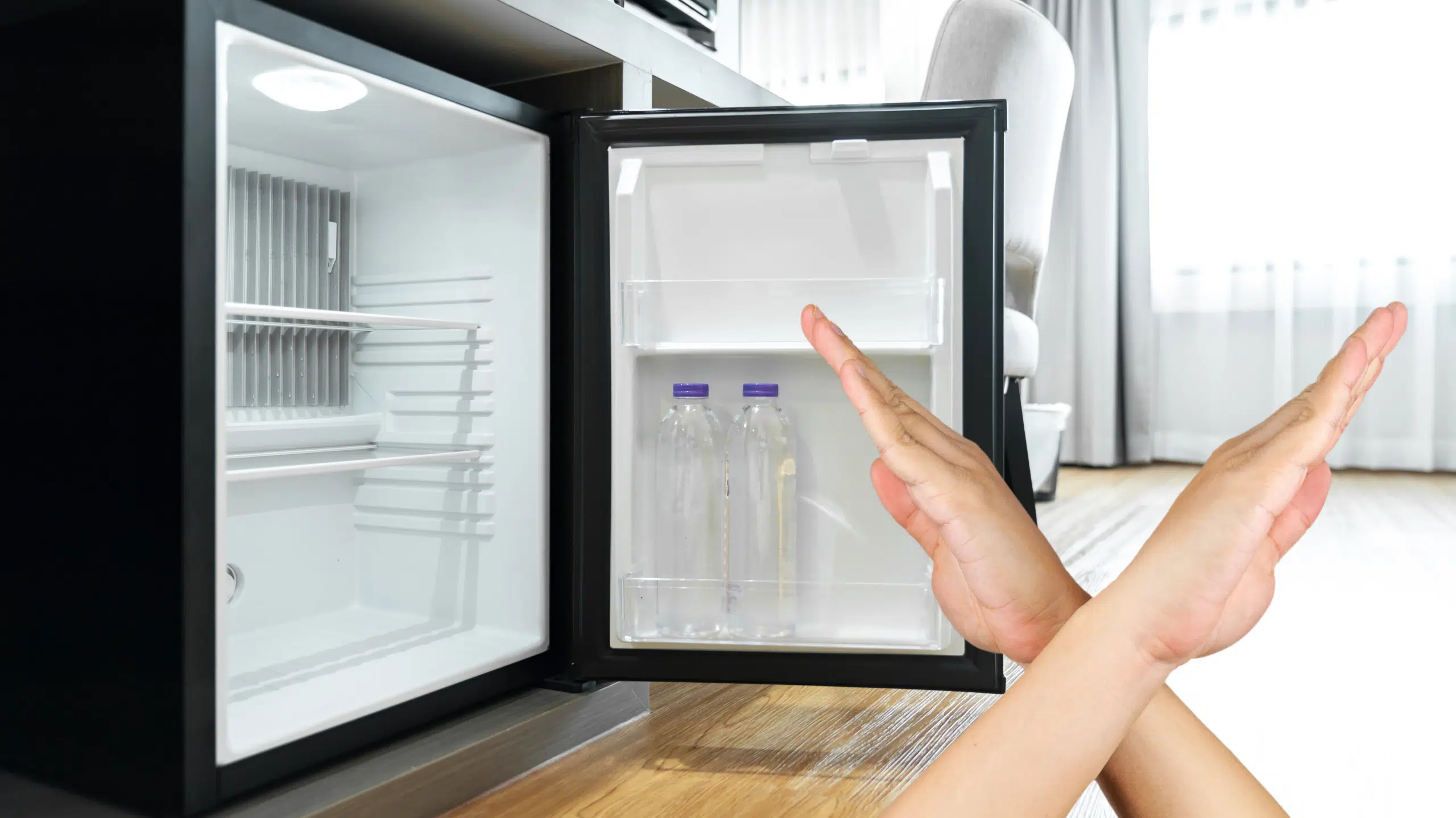 bottle fridge cooler with a person hands indicating that its not working