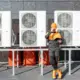 Engineers standing besides commercial air conditioning units