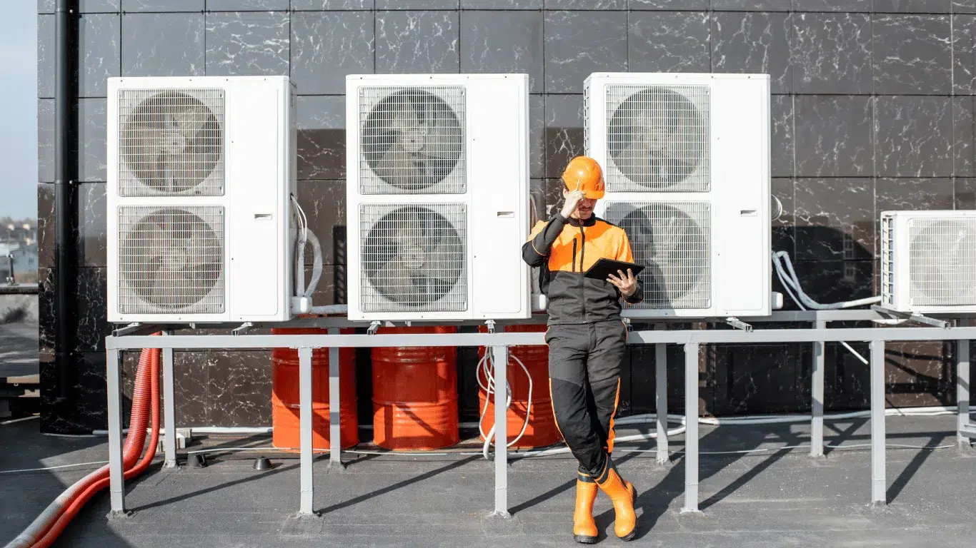 Engineers standing besides commercial air conditioning units